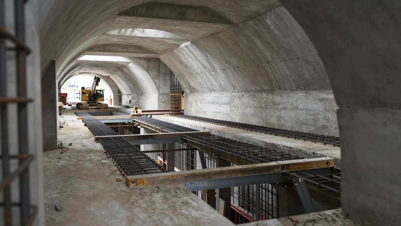 Interior de túnel en construcción para línea de subte con estructura de hormigón armado, rieles y maquinaria de obra