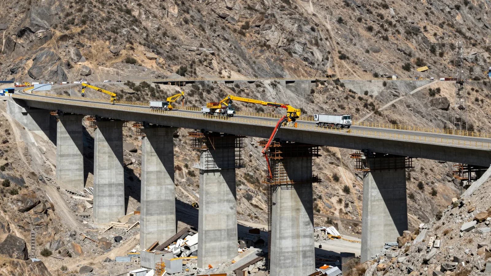 Puente elevado bajo construcción en un paisaje árido y montañoso